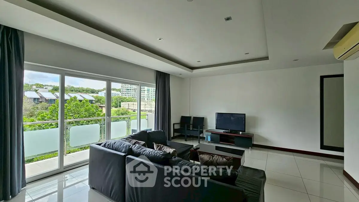 Spacious modern living room with large windows and sleek furniture, offering a bright and airy atmosphere.