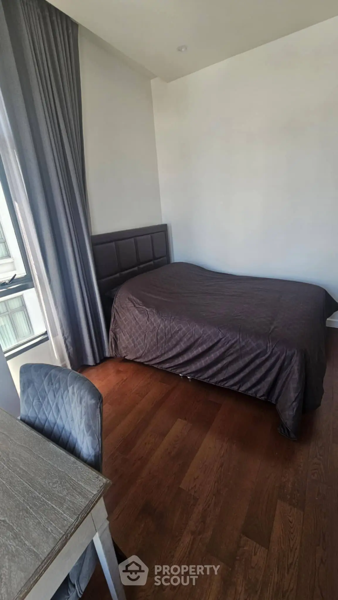 Cozy bedroom with wooden flooring and modern furnishings, perfect for a restful retreat.