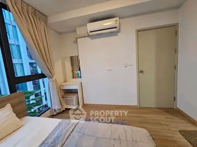 Modern bedroom with large window and air conditioning in a stylish apartment.