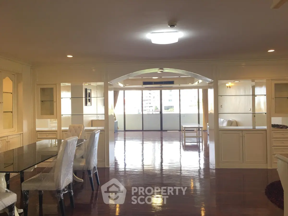 Spacious open-plan living room with elegant dining area and large balcony view.