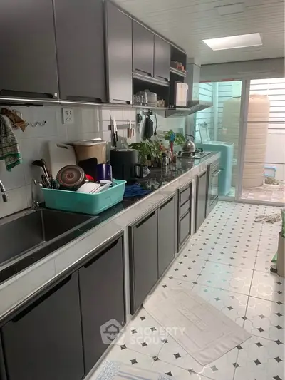 Spacious kitchen with modern black cabinetry and large windows for natural light.