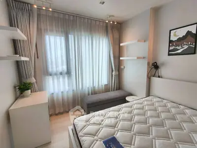 Modern bedroom with stylish decor and natural light, featuring a comfortable bed and elegant curtains.