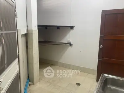 Compact storage room with shelves and tiled floor, ideal for organizing household items.