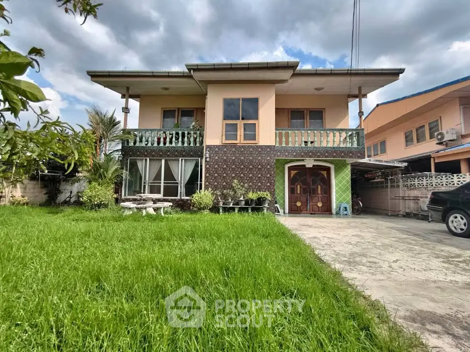 Charming two-story house with lush green lawn and spacious driveway, perfect for family living.