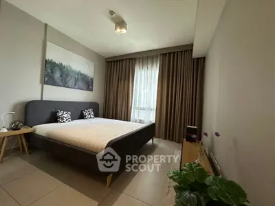 Modern bedroom with stylish decor and large window for natural light.