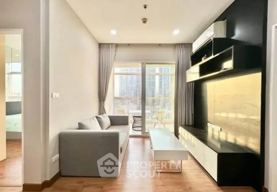 Modern living room with sleek furniture and large windows offering city views