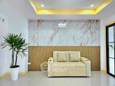 Modern living room with elegant marble accent wall and cozy beige sofa.