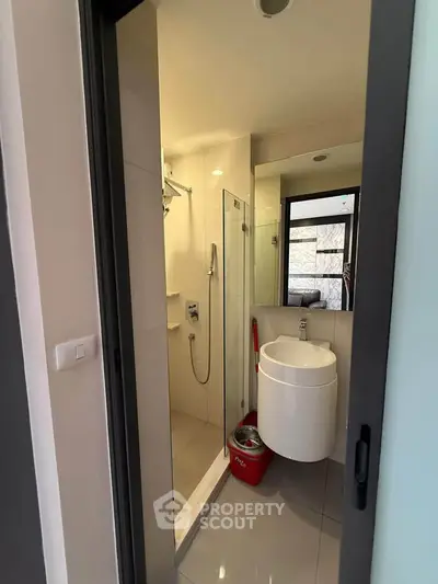 Compact modern bathroom with sleek fixtures and glass shower enclosure
