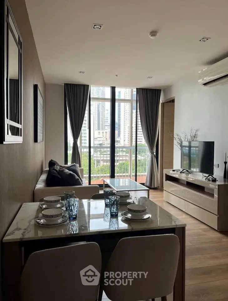 Modern living room with city view, stylish furniture, and elegant decor in a high-rise apartment.