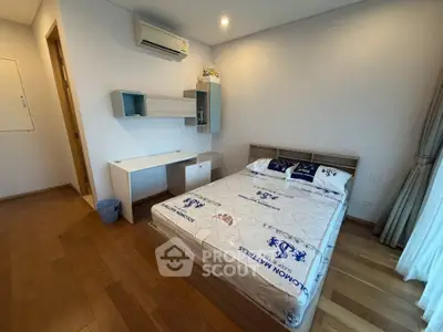 Modern bedroom with wooden flooring and stylish furniture in a cozy apartment.