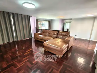 Spacious living room with elegant parquet flooring and modern leather sofa.