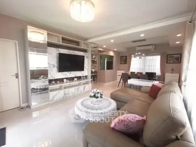 Spacious living room with elegant decor and modern furnishings, featuring a large sofa and wall-mounted TV.