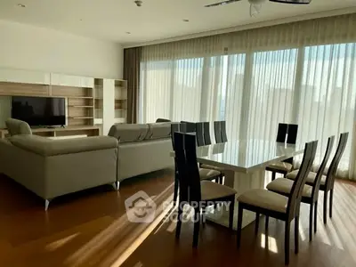 Spacious modern living and dining area with large windows and elegant furniture.