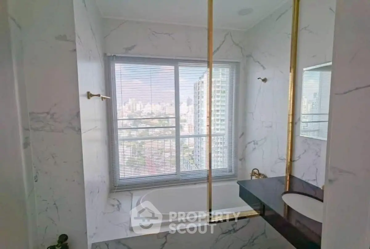 Luxurious bathroom with city view, marble finishes, and elegant fixtures.