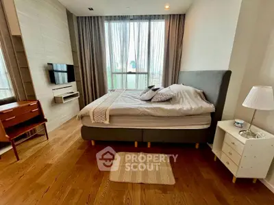 Spacious bedroom with modern decor and large window for natural light.