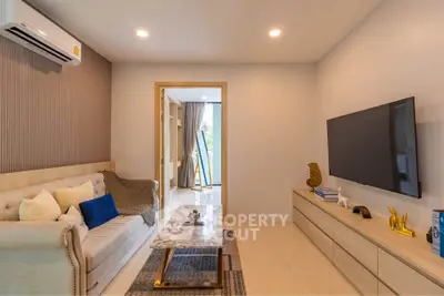 Modern living room with stylish decor and large TV, perfect for relaxation and entertainment.