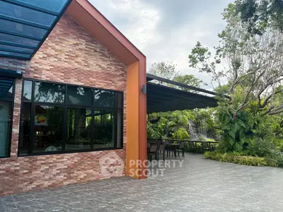 Modern building exterior with spacious patio and lush garden view.