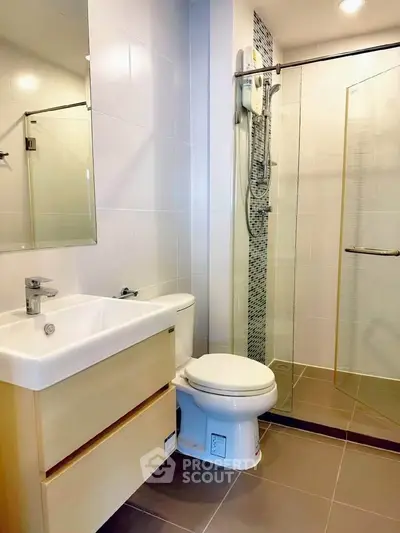 Modern bathroom with glass shower and sleek fixtures in a contemporary apartment.
