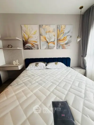Elegant bedroom with modern decor and stylish artwork, featuring a plush bed and natural light.