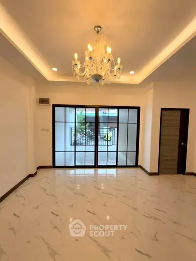 Elegant living room with chandelier and sliding glass doors