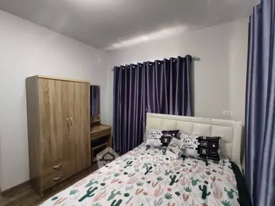 Cozy bedroom with stylish decor and wooden furniture, perfect for a comfortable living experience.