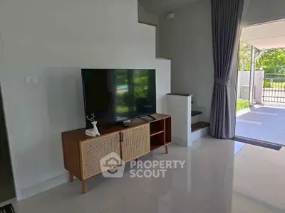 Modern living room with sleek TV stand and open view to garden
