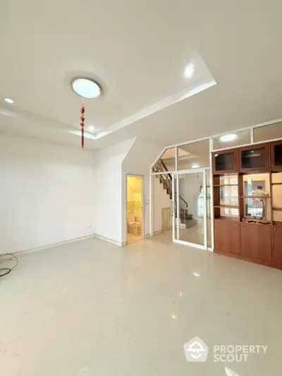 Spacious modern living room with staircase and glass partition