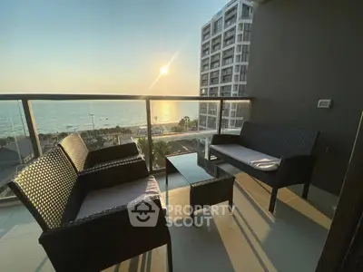 Stunning balcony with ocean view and modern outdoor seating at sunset.