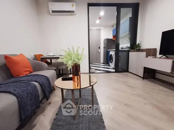 Modern living room with stylish decor and open kitchen layout in a cozy apartment.