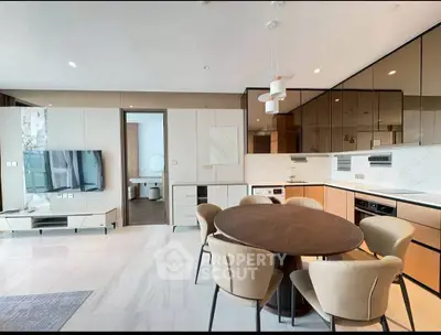 Modern open-plan living and dining area with sleek kitchen and stylish furniture.