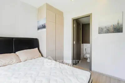 Modern bedroom with ensuite bathroom and sleek wooden wardrobe