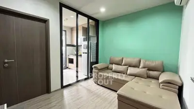 Modern living room with green accent wall and cozy beige sectional sofa