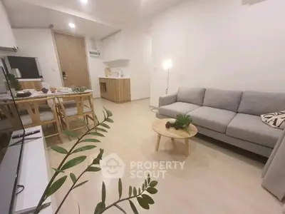 Modern living room with cozy gray sofa, wooden dining set, and minimalist decor in bright apartment.
