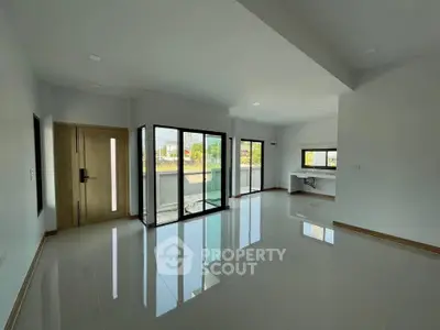 Spacious modern living room with large windows and balcony access