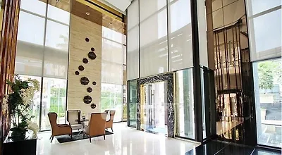 Luxurious high-ceiling lobby with modern decor and elegant seating area in upscale building.