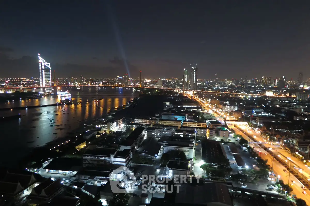 Stunning night cityscape view from high-rise building overlooking illuminated skyline and waterfront.