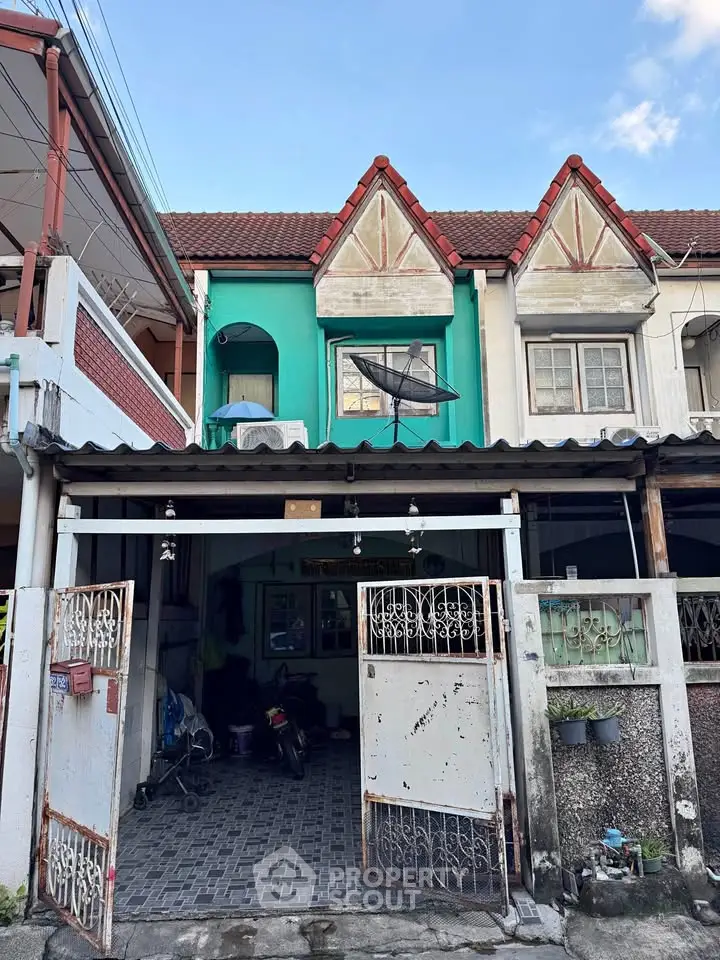 Charming townhouse with unique facade and gated entrance in a vibrant neighborhood.