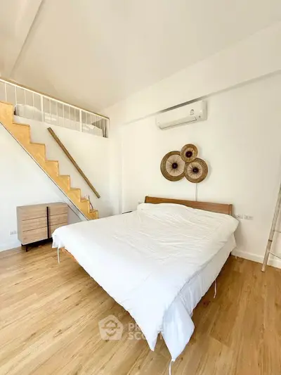 Modern bedroom with loft, wooden flooring, and stylish decor
