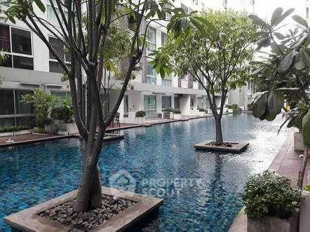 Luxurious condominium pool area with lush greenery and modern design.
