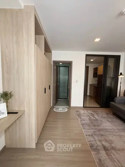 Modern living room with sleek wooden flooring and open kitchen layout