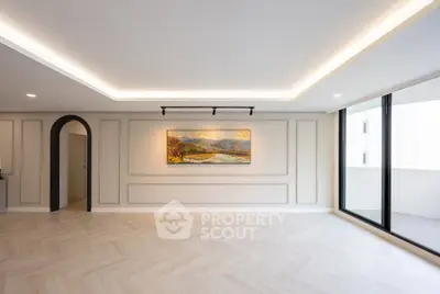 Spacious modern living room with elegant lighting and large balcony access.