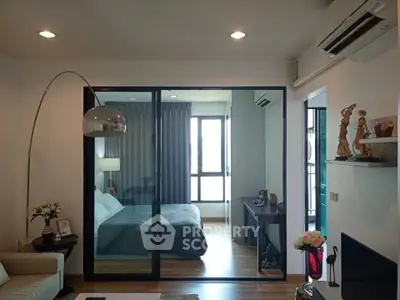 Modern living room with open view to stylish bedroom, featuring elegant decor and natural light.
