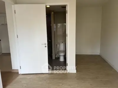 Spacious interior with wooden flooring and bathroom access, ideal for modern living.