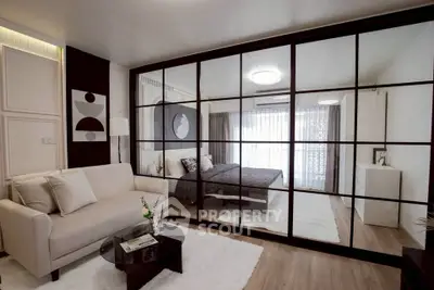 Modern studio apartment with glass partition, cozy living area, and stylish bedroom.