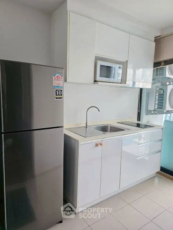 Modern kitchen with sleek white cabinets and stainless steel fridge