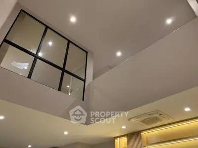 Modern interior with high ceiling and recessed lighting, featuring a sleek air conditioning unit.