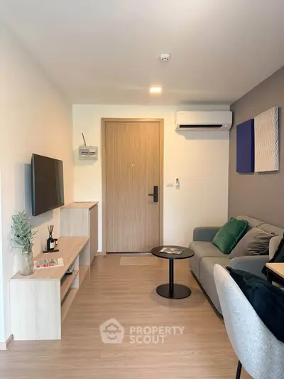 Modern living room with sleek furniture and wall-mounted TV in a cozy apartment.