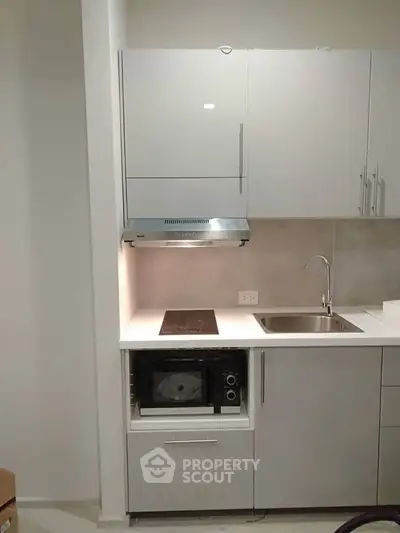Modern compact kitchen with sleek cabinetry and built-in appliances