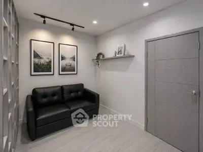 Modern minimalist living room with black leather sofa and stylish wall art.