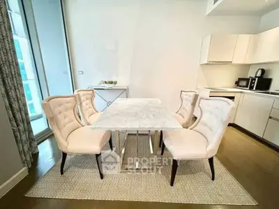 Elegant dining area with marble table and plush chairs in modern kitchen setting.